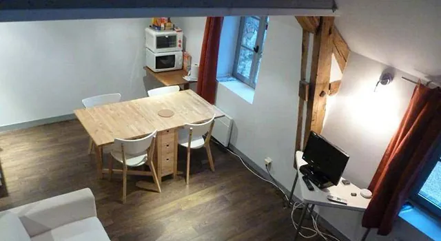 Salle à manger et coin salon vus d’en haut, table, chaises, canapé et télévision