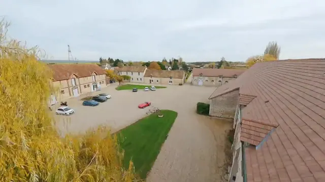 Vue drone au-dessus de la cour du campus de Marcq : toits de tuiles, cour et voitures garées