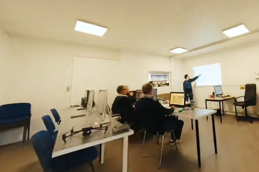 Salle de formation du campus : stagiaires devant des écrans, formateur au tableau, drone posé sur une table